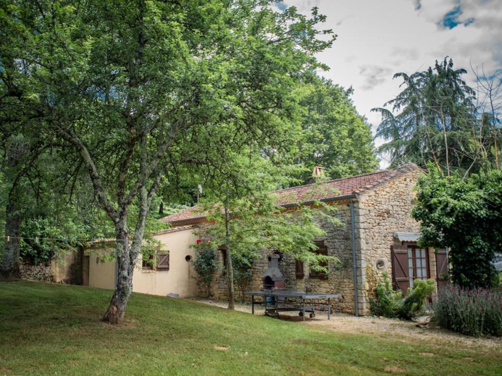 una casa in pietra con un tavolo da picnic in un cortile di Gite Le Pasturale a Prats-du-Périgord