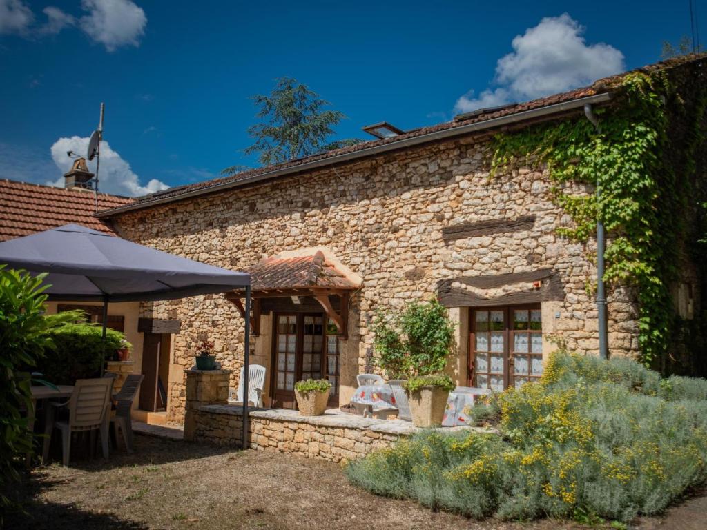 kamienny dom z patio w ogrodzie w obiekcie Le Tilleuil en Périgord w mieście Prats-du-Périgord
