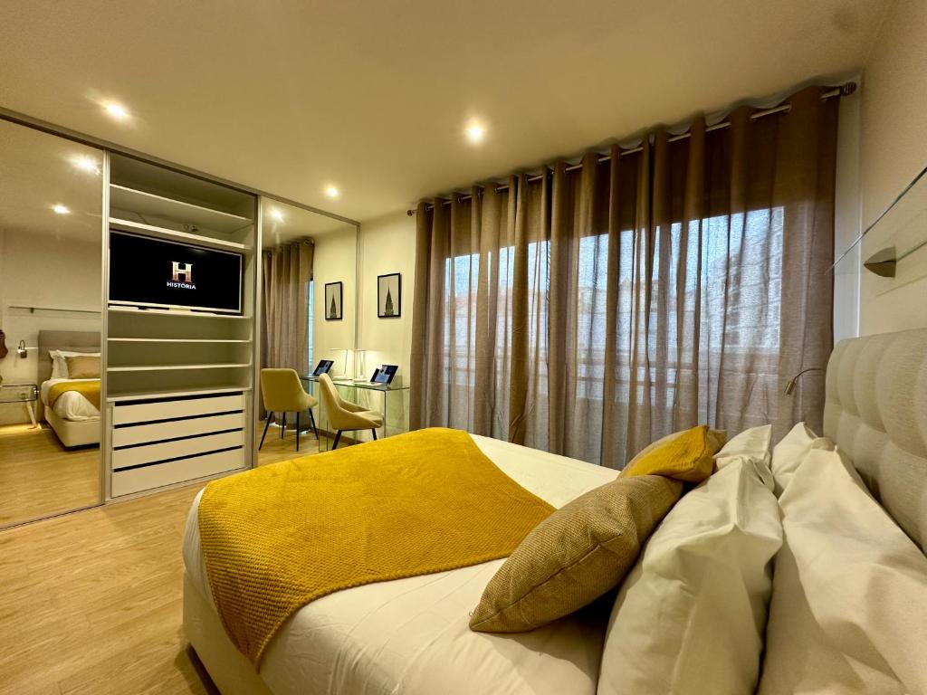 Un dormitorio con una cama con una manta amarilla encima. en Living Funchal V, en Funchal