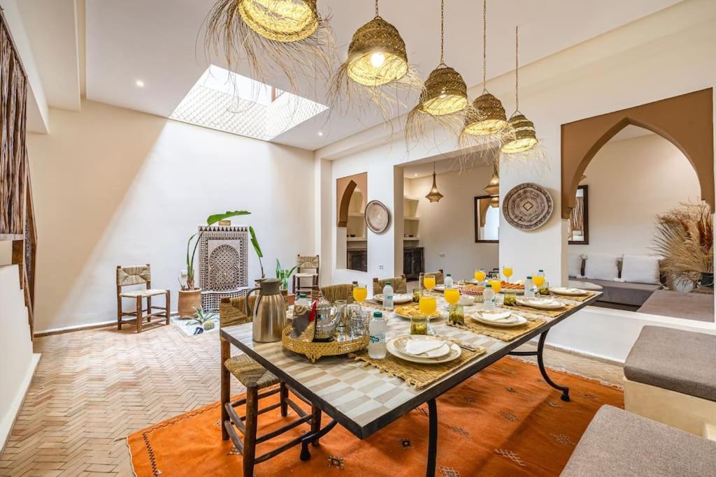 a dining room and living room with a table and chairs at Riad Macan Exclusive and Trendy Chich Breakfast incl in Marrakech