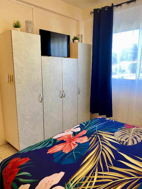 a bedroom with a bed with a colorful comforter at Heiata Lodge Papeete in Papeete