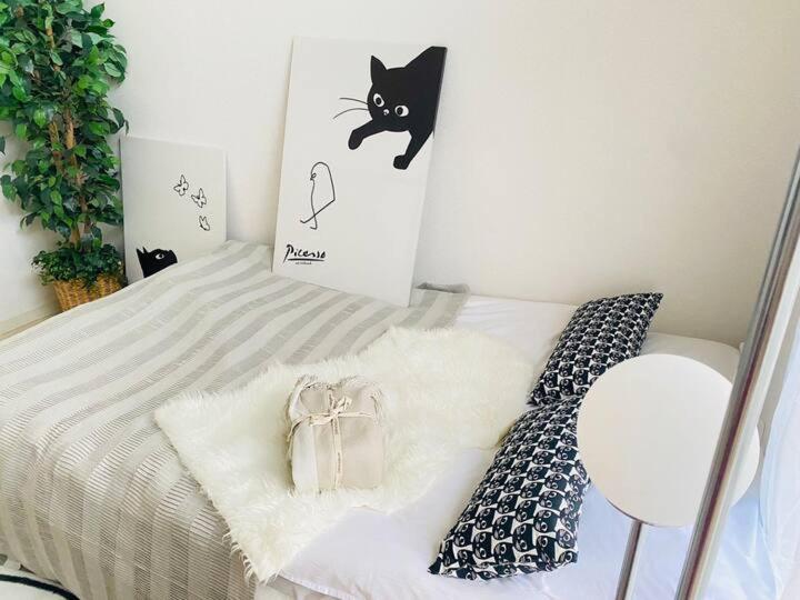 a bedroom with a bed with a black cat on the wall at A21 Shinjuku center-4mins to room 10min to Kabukicho-新宿商圈Loftoom 021 in Tokyo