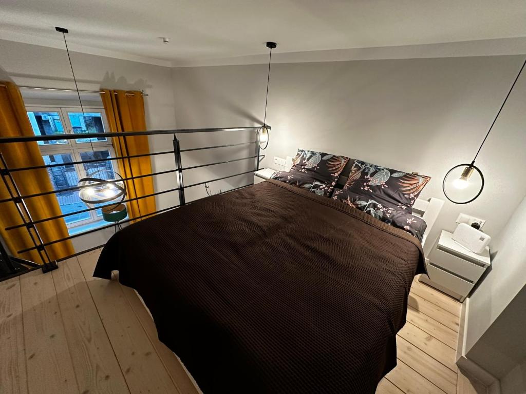 a bedroom with a large bed with two lights at Apartament Jelonka in Jelenia Góra