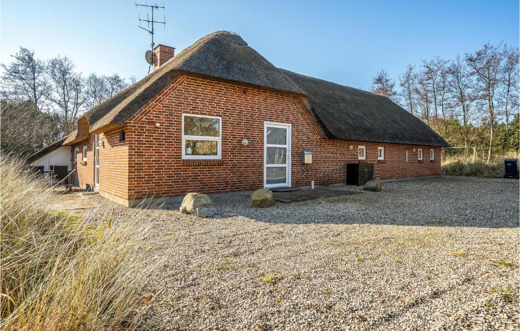 ブラーバンドにあるAmazing Home In Blåvand With Kitchenの茅葺き屋根の小さなレンガ造りの建物