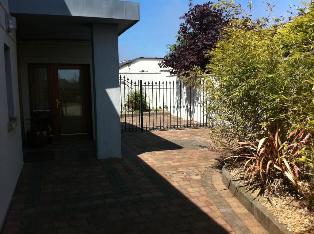 a house with a gate and a brick walkway at Bearlough Self Catering Holiday Home in Rosslare