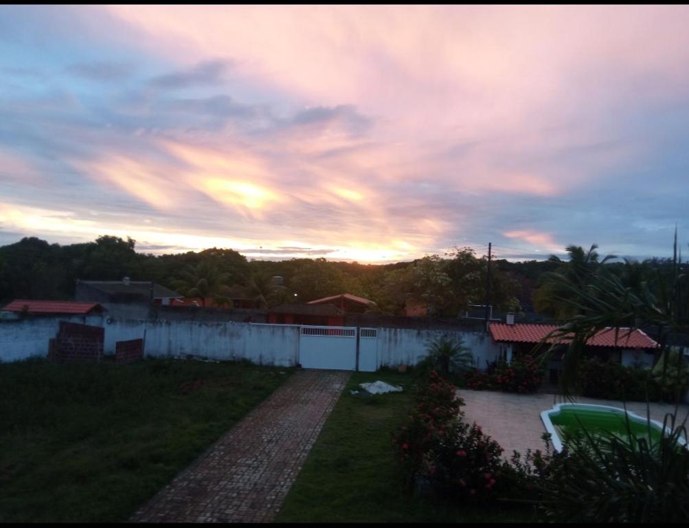 een uitzicht op de zonsondergang vanuit een huis met een tuin bij Sítio esperança in Camassari
