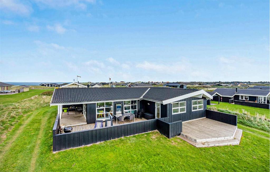 una grande casa nera con un grande ponte di 4 Bedroom Stunning Home In Hjørring a Hjørring