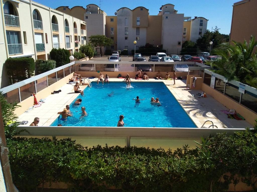 un groupe de personnes dans une piscine dans l'établissement **Gruissan : T2 cosy avec piscine, parking privé, proche plage et commerces** - FR-1-796-8, à Gruissan