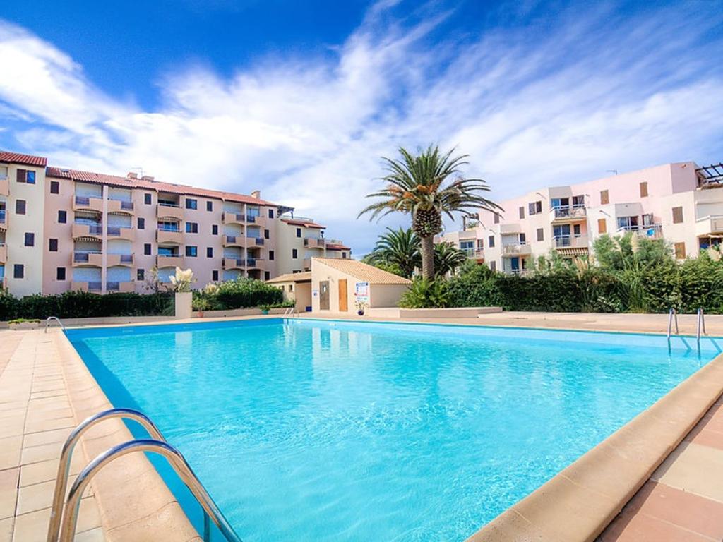 une grande piscine devant certains immeubles d'habitation dans l'établissement Studio Alcôve en Front de Mer avec Piscine, Terrasse et Parking à Saint Cyprien - FR-1-793-14, à Saint-Cyprien
