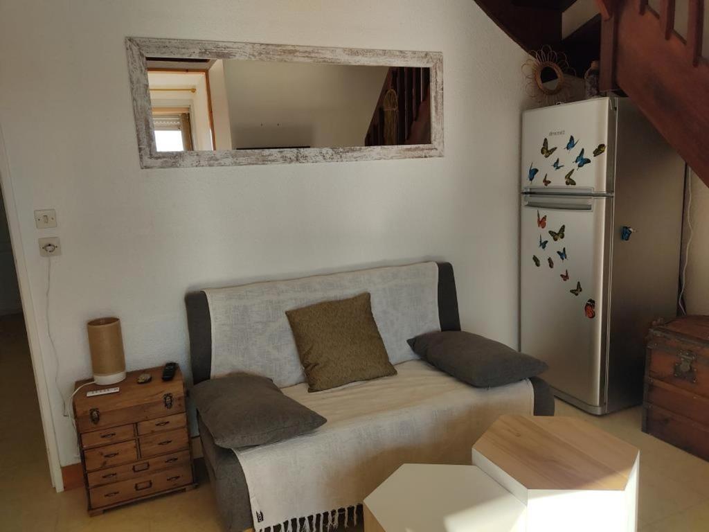Cette petite chambre dispose d'un canapé et d'un réfrigérateur. dans l'établissement Gruissan - Spacieux T2 Mezzanine - 6 Pers - Parking - FR-1-796-22, à Gruissan