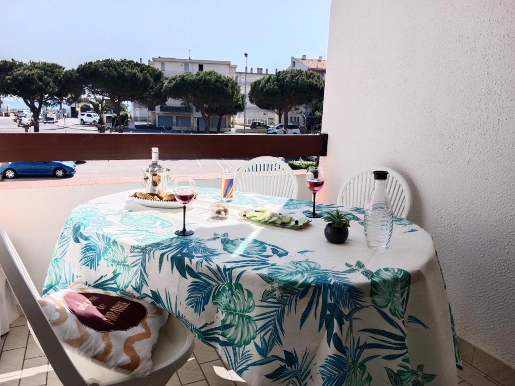 une table avec une assiette de nourriture et des verres de vin dans l'établissement T2 avec Alcôve à Saint-Cyprien, PKG, Proche Plage - FR-1-793-8, à Saint-Cyprien