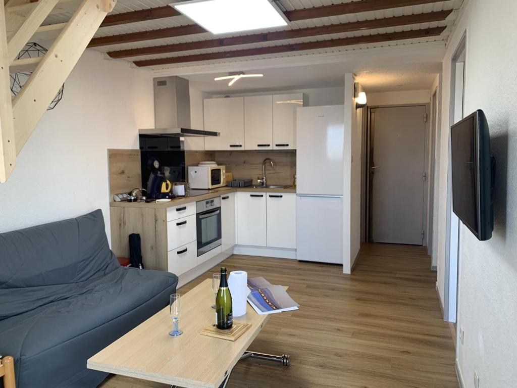 un salon avec un canapé et une table dans l'établissement Gruissan - T2 Mezzanine Climatisé Proche Plage - 5/6 Pers - Parking Privé - Tout Équipé - FR-1-796-23, à Gruissan