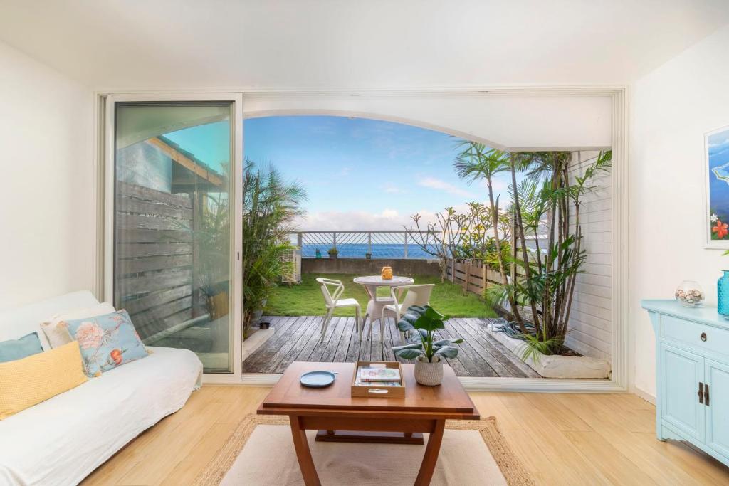 a living room with a view of the ocean at Sunset Beach Residence - Studio on the beach in Punaauia