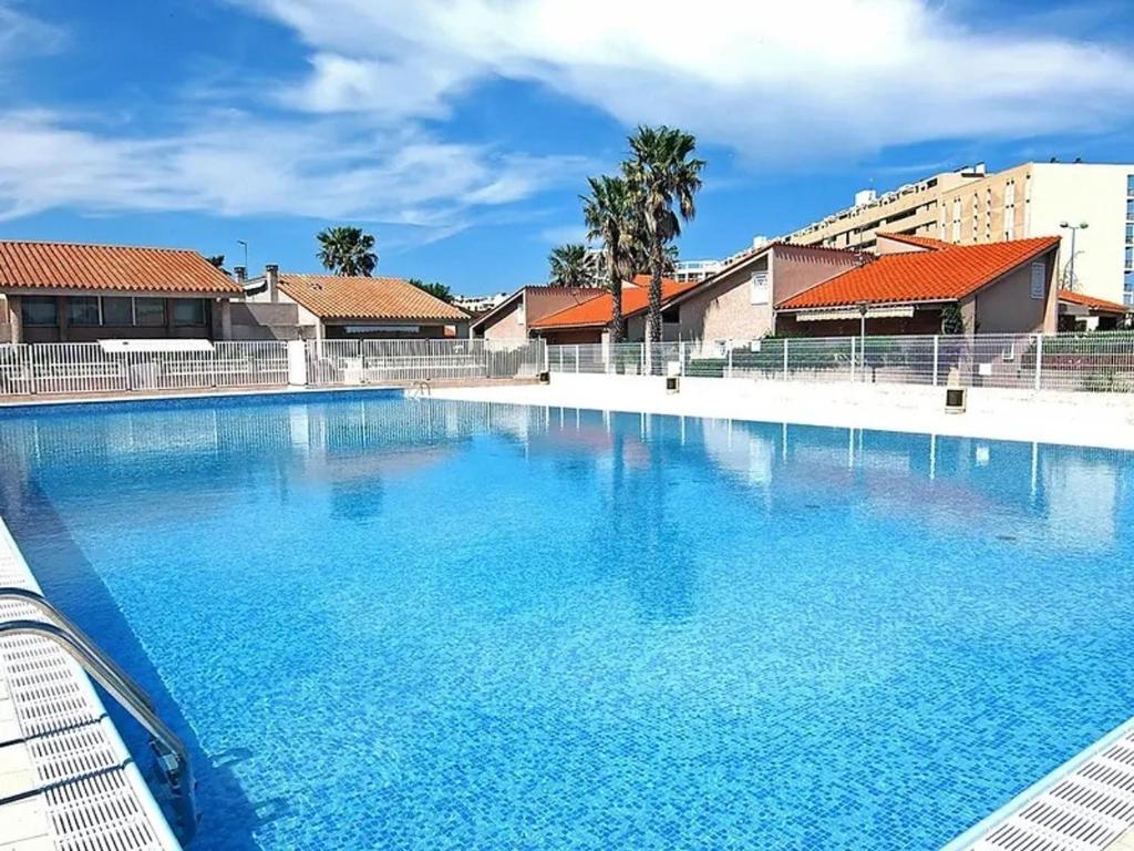 une grande piscine avec de l'eau bleue dans l'établissement Villa T3 Mezzanine 6P - Piscine, Parking, Proche Plage et Port à Saint-Cyprien - FR-1-793-25, à Saint-Cyprien
