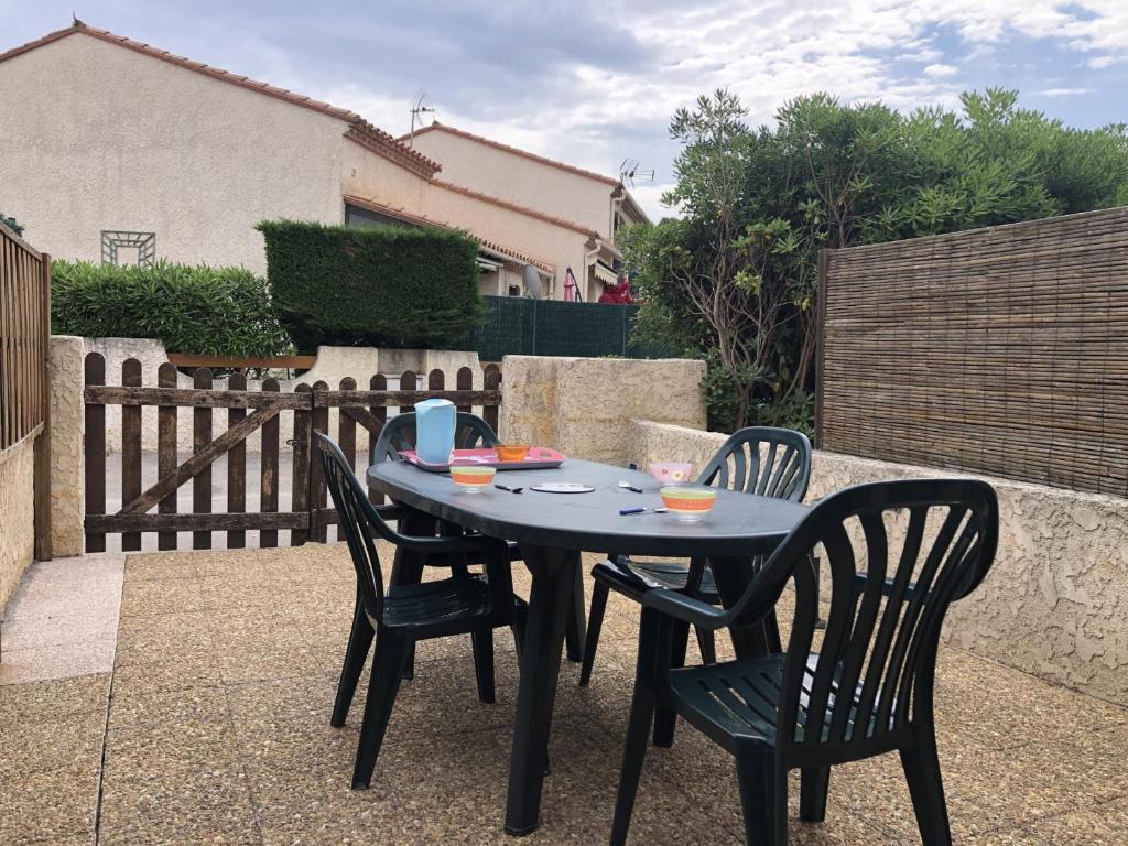une table noire et des chaises sur une terrasse dans l'établissement Villa T3 Mezzanine 6P Centre Saint-Cyprien, Proche Plage et Port - FR-1-793-26, à Saint-Cyprien