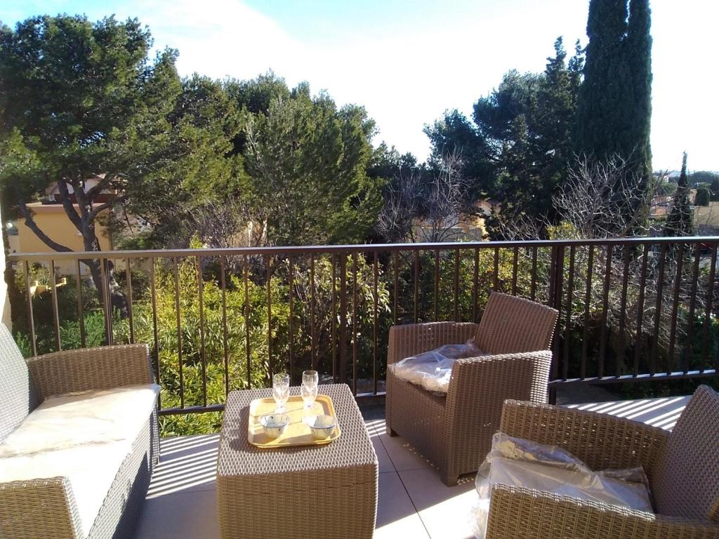 un balcon avec des chaises et une table avec un plateau dessus dans l'établissement Villa 8 pers, proche plage, terrasse, secteur calme, animaux ok, Gruissan - FR-1-796-67, à Gruissan