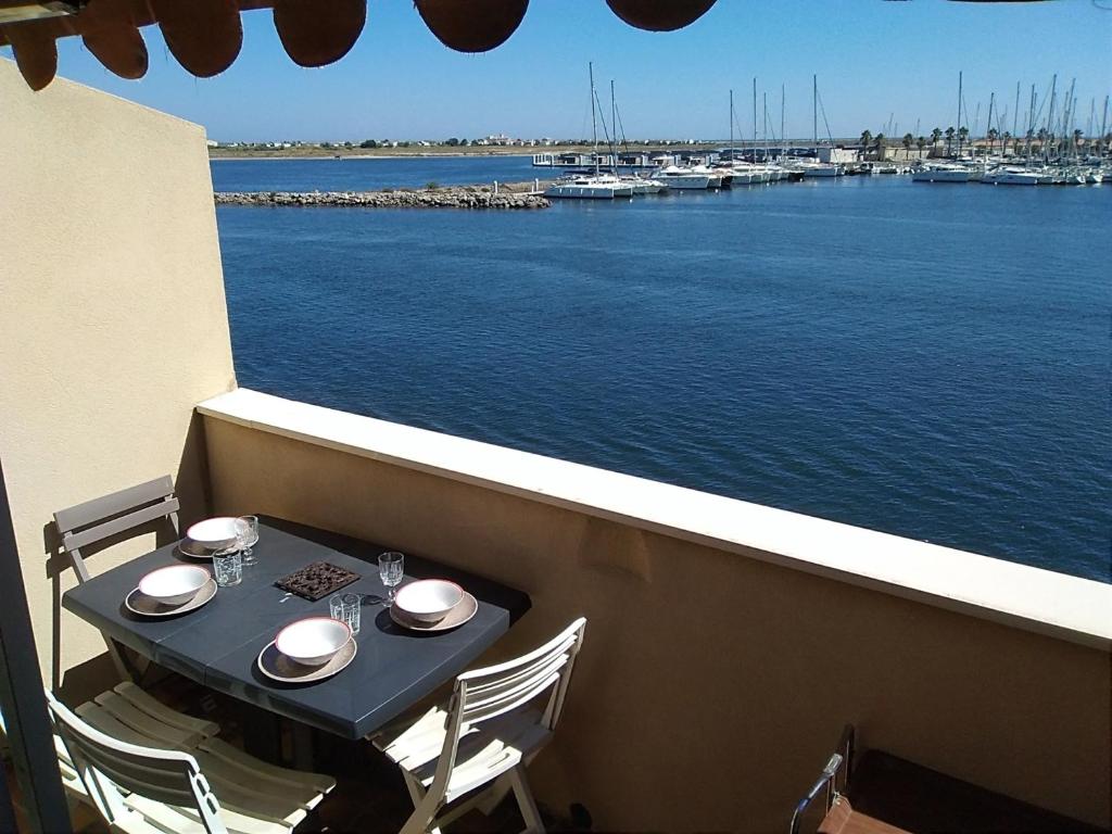 - une table sur un balcon avec vue sur le port de plaisance dans l'établissement Studio Alcôve 4 Pers, Proche Plage, Parking Privé - FR-1-796-32, à Gruissan