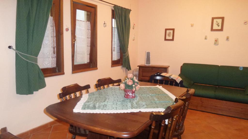 タオルミーナにあるApartment San Pancrazioのダイニングルーム(テーブル、緑のソファ付)
