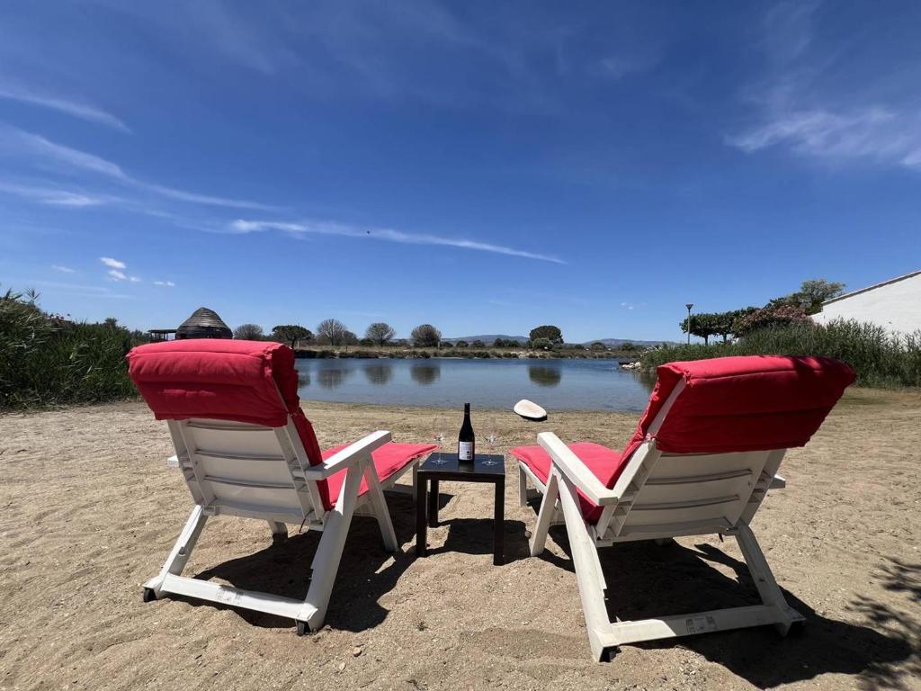 2 chaises et une table avec une bouteille de vin dans l'établissement Villa T3 climatisée avec WIFI, proche plage, 5 pers - FR-1-81-620, au Barcarès