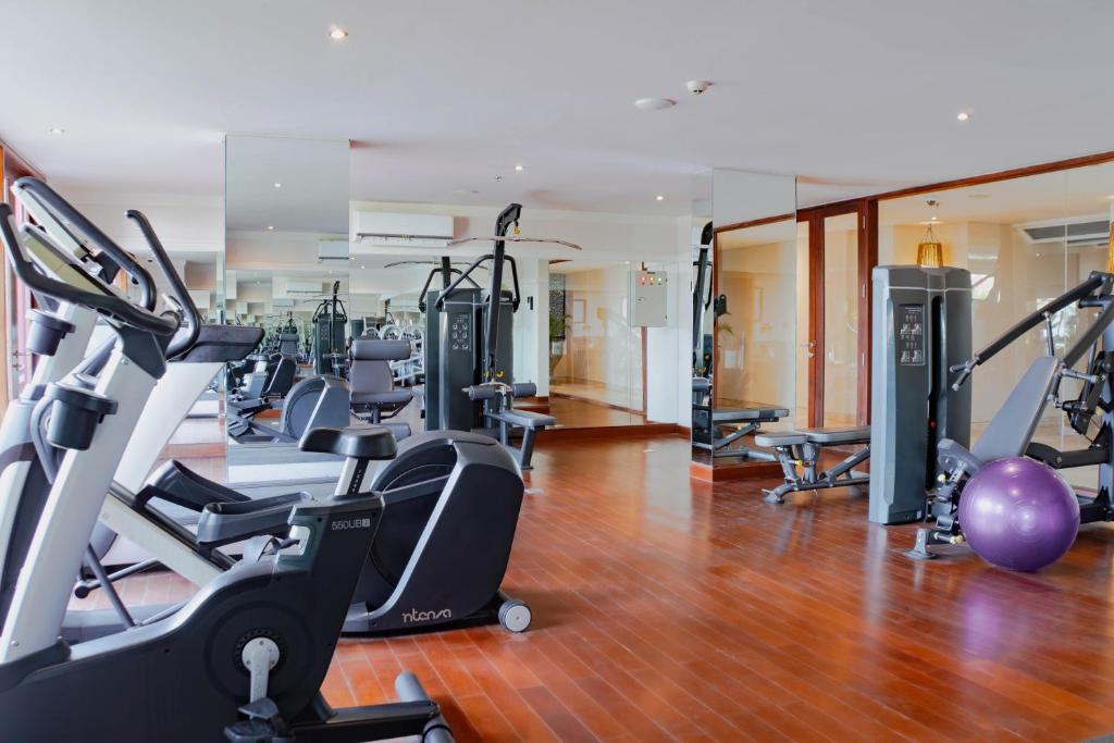 a gym with several treadmills and exercise bikes at Amnaya Resort Kuta in Kuta