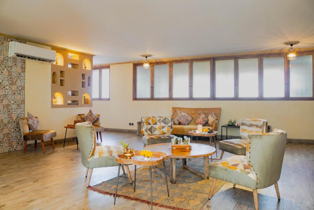 a living room with couches and a table and chairs at Amnaya Resort Kuta in Kuta