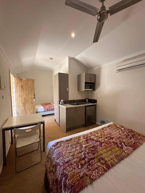 una camera da letto con un letto, un tavolo e una cucina di Parachilna Overflow Accommodation a Flinders Ranges