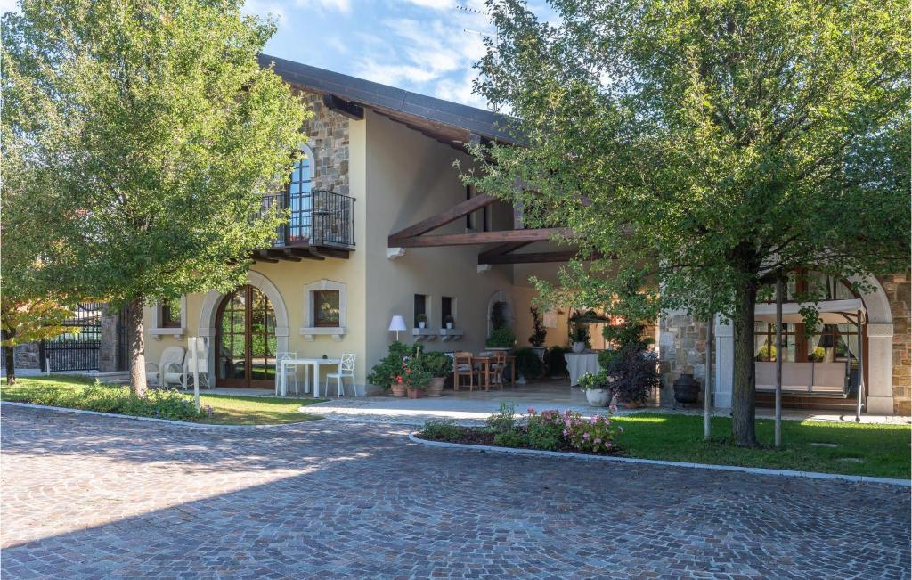 un bâtiment avec des arbres et une rue pavée dans l'établissement Apt Braida, à Corona