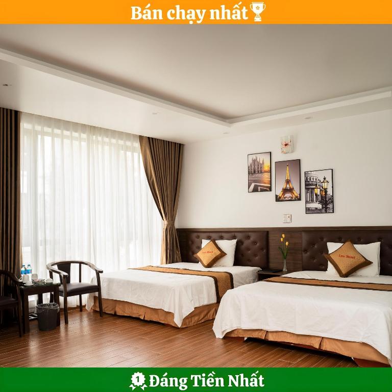 a hotel room with two beds and a table at Lux Hotel FLC Sầm Sơn in Sầm Sơn