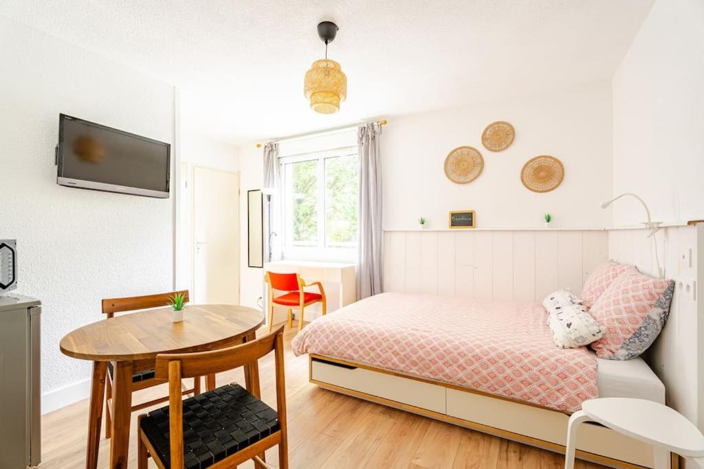 une petite chambre avec un lit et une table dans l'établissement Studio Elie, à Grenoble