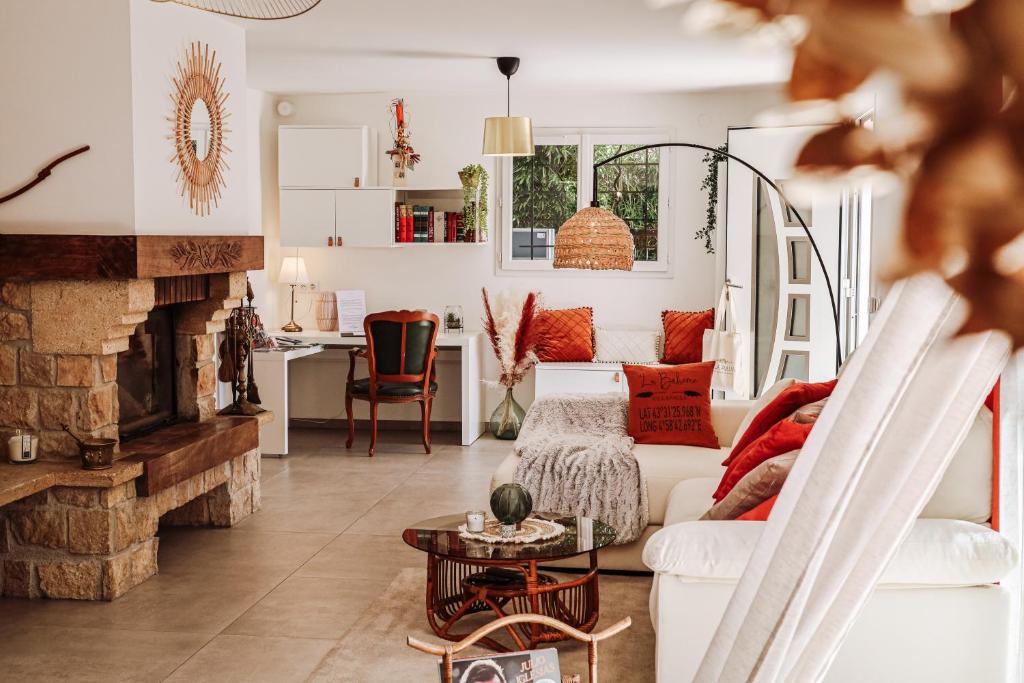 een woonkamer met een witte bank en een open haard bij La Bohème - VILLA PAULA in Istres