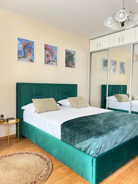a bedroom with a large bed with a green headboard at Studio near Copou Hospitals IRO Parhon in Iaşi