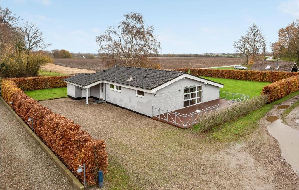 a small white house in the middle of a field at Holiday Home Egernsund With Patio 319 in Egernsund