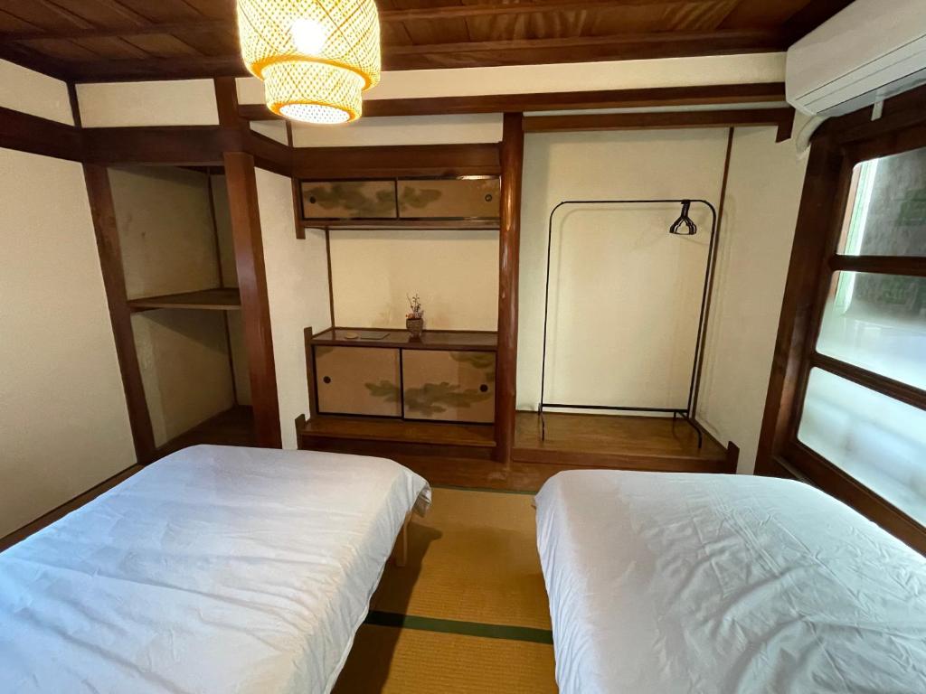 a bedroom with a white bed and a window at Guest House BONITO in Kochi