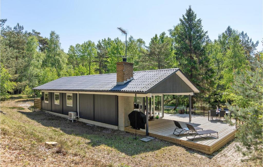 Una casa pequeña con terraza y un jardín de conservación. en Holiday Home Nexo L, en Spidsegård