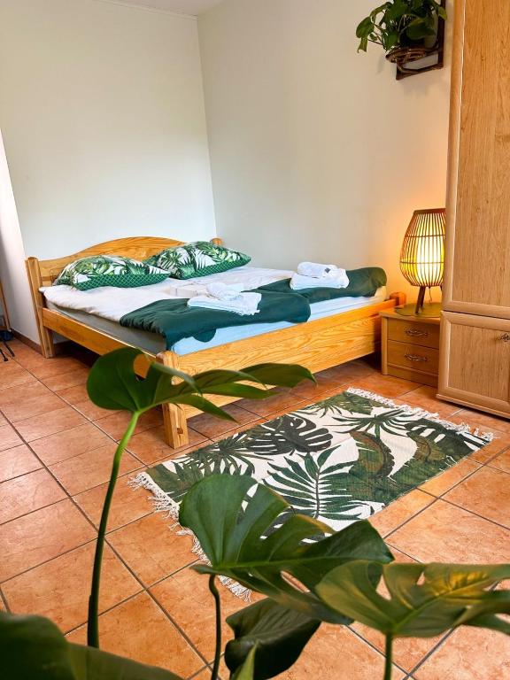 a bedroom with a bed and a plant at Kokosek Pokoje Gościnne in Mielno