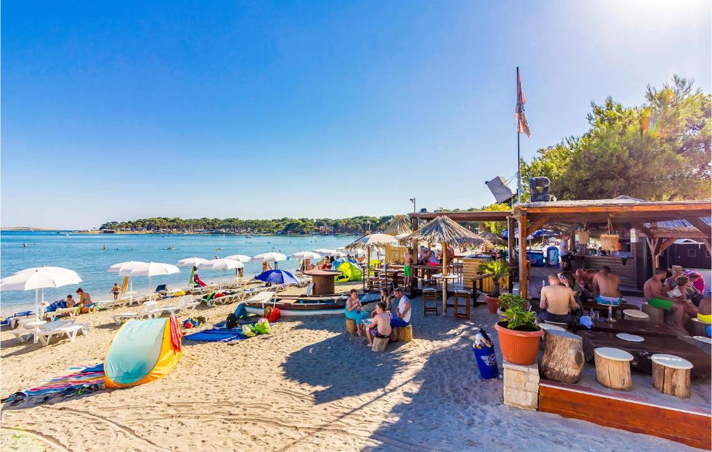grupa ludzi siedząca na plaży w obiekcie Holiday Home Medulin 33 w Medulinie