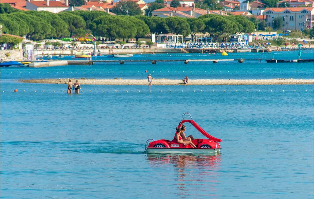 osoba pływająca czerwonym rowerem wodnym w wodzie w obiekcie Holiday Home Medulin 33 w Medulinie