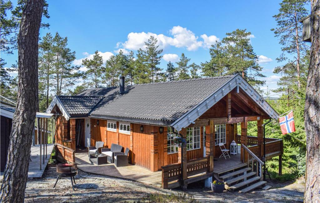eine Blockhütte im Wald mit einer Veranda und einer Terrasse in der Unterkunft Four-Bedroom Holiday Home In Kornsjo in Kornsjø