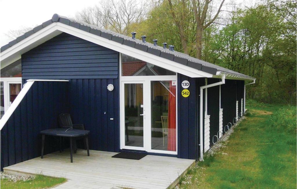 トラフェミュンデにあるSchmugglerstieg 13D - Dorf 5の木製のデッキに椅子が置かれた青い小屋