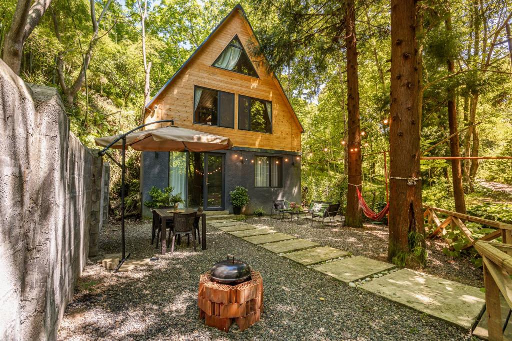 VenoSea Tsikhisdziri Seaside Cottage في تسيكهيسدزيري: منزل صغير في الغابة مع حفرة نار
