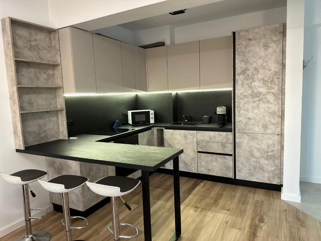 a kitchen with a table and two stools at Zenit Apartment Oradea in Oradea