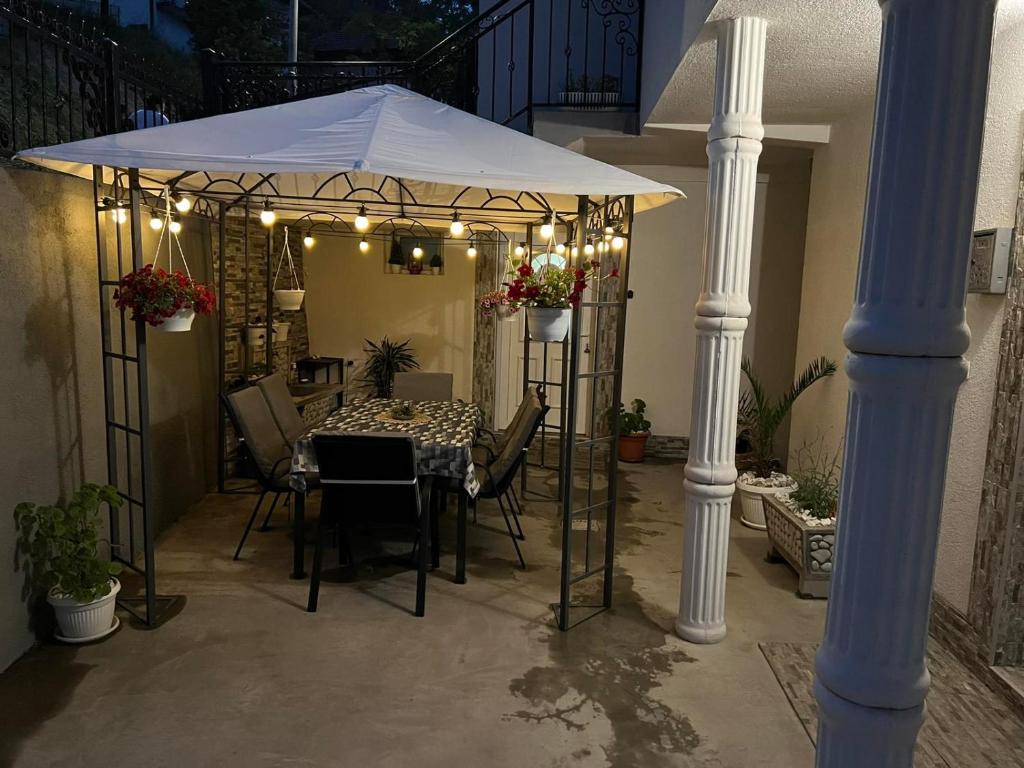 a patio with a table and a white umbrella at Apartman Royal sa GARAŽOM i KLIMOM in Visoko
