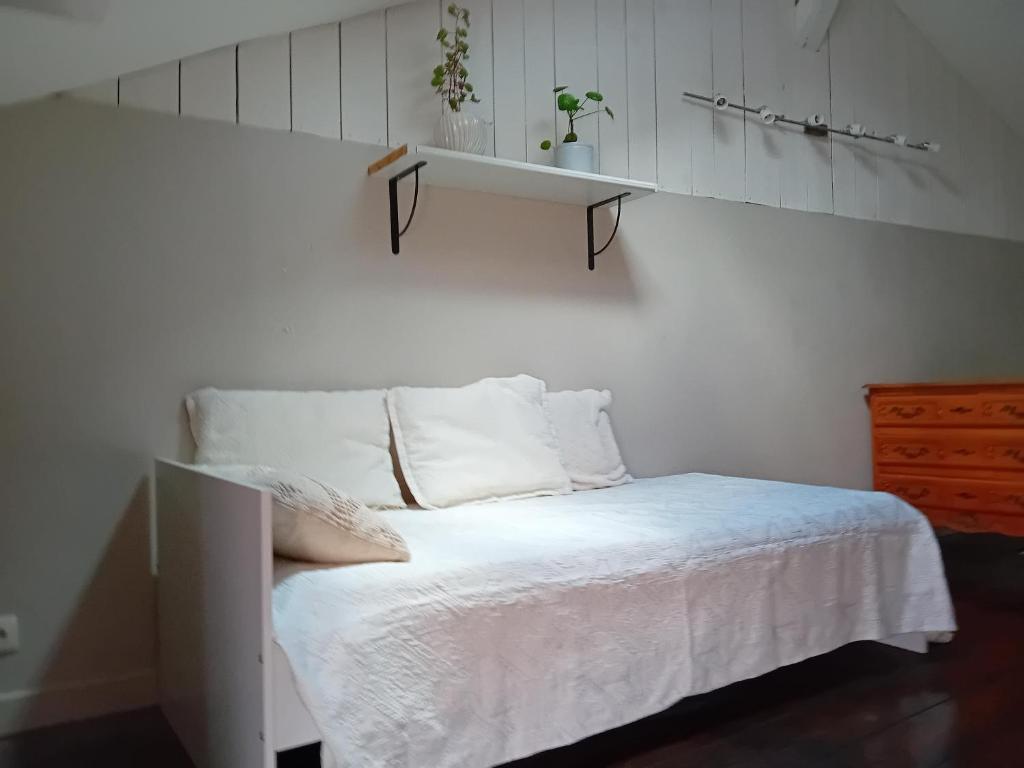 - une chambre avec un lit avec une étagère sur le mur dans l'établissement Charmante maison de ville proche rivière, à Saint-Maixent-lʼÉcole