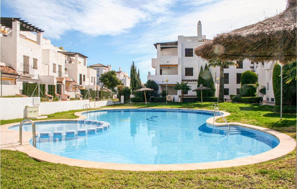 a large blue swimming pool in a yard with buildings at 3 Bedroom Nice Apartment In Alcossebre in Alcossebre