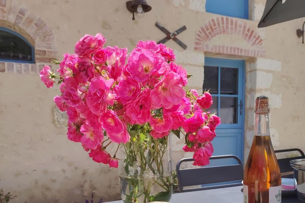 un vase rempli de fleurs roses sur une table dans l'établissement Closerie de Montaimé, à Amboise