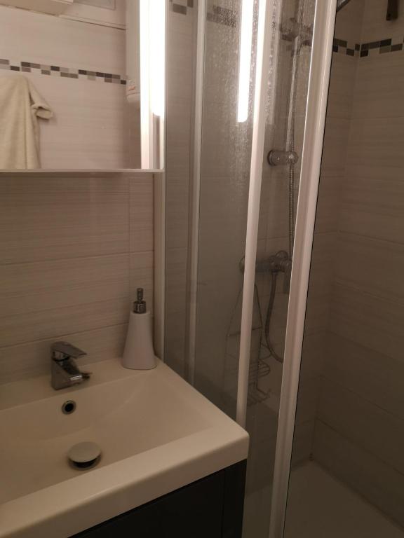 une salle de bain avec un lavabo et une douche dans l'établissement Bien au calme, à La Londe-les-Maures