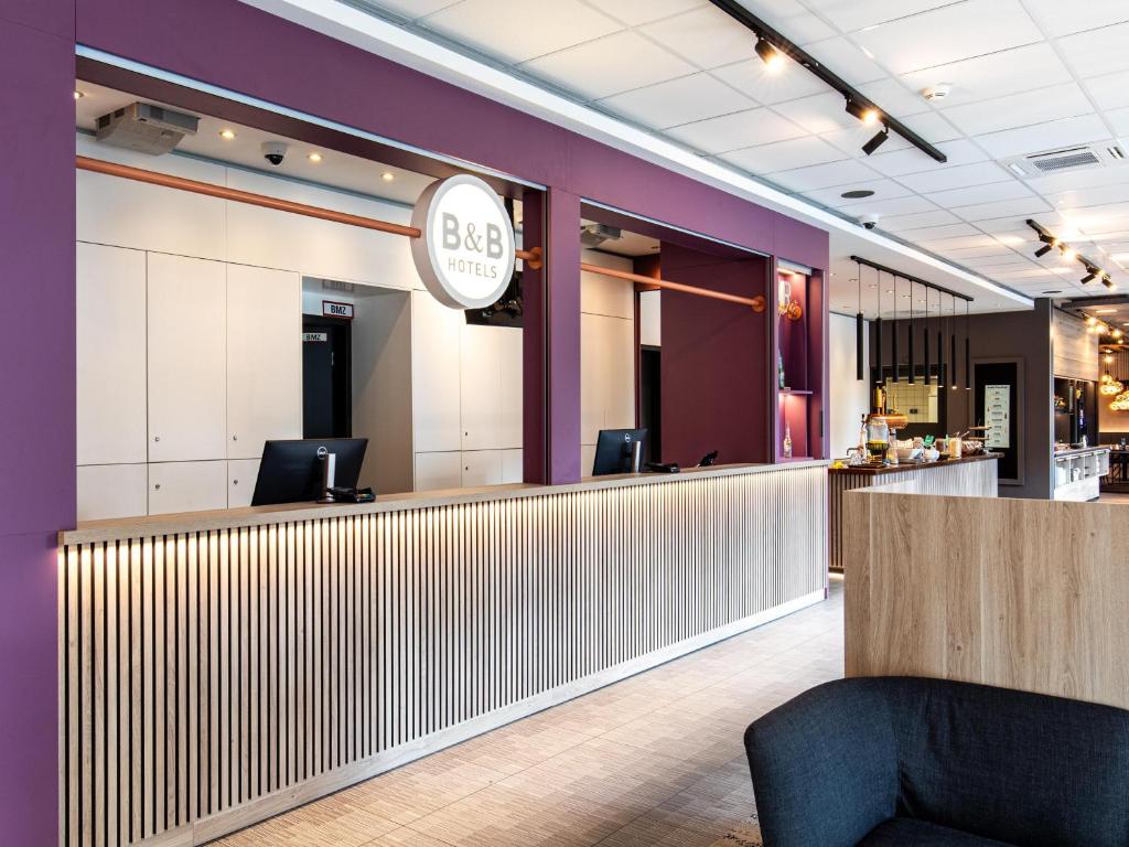 a bar in a restaurant with purple walls at B&B Hotel Hamburg-Airport in Hamburg