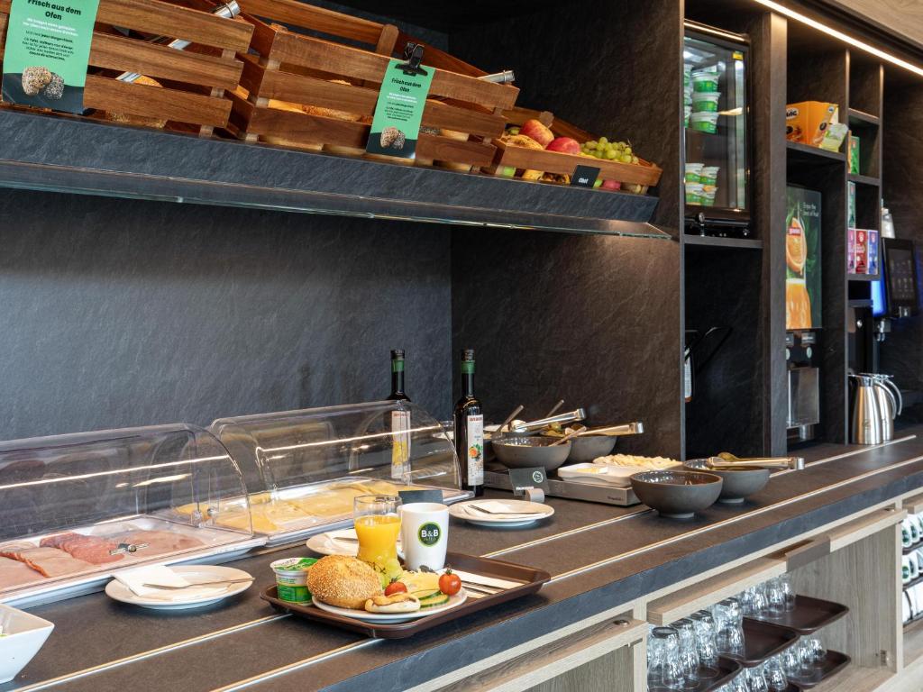 a buffet line with plates of food and drinks at B&B Hotel Hamburg-Airport in Hamburg