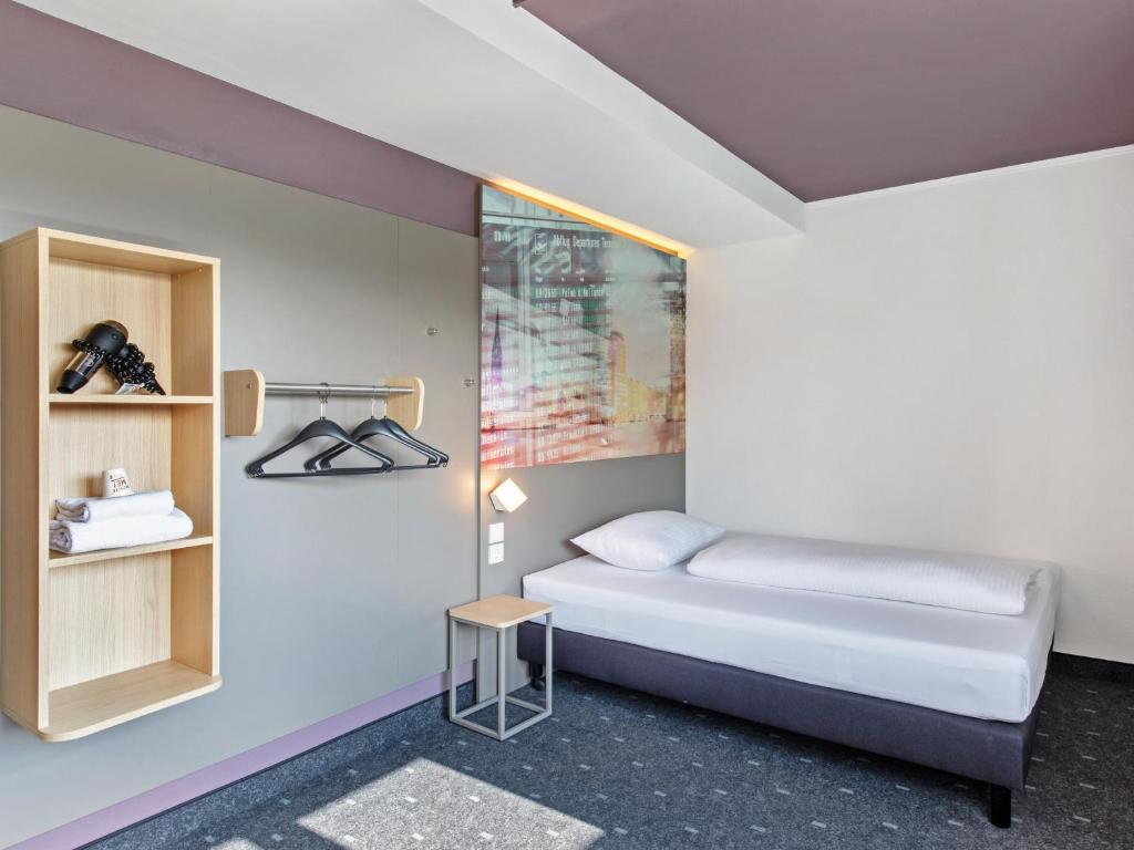 a small bedroom with a bed and a small table at B&B Hotel Hamburg-Airport in Hamburg
