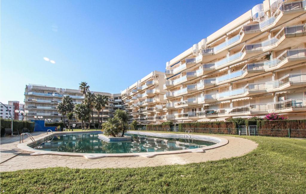 a large apartment building with a pool in front of it at Nice Apartment In Mont-Roig Del Camp in Miami Platja